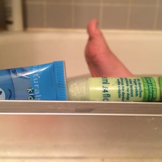 Bottles of bath paints in between the rails of the shower door lots of bath time fun! #365 Feature image